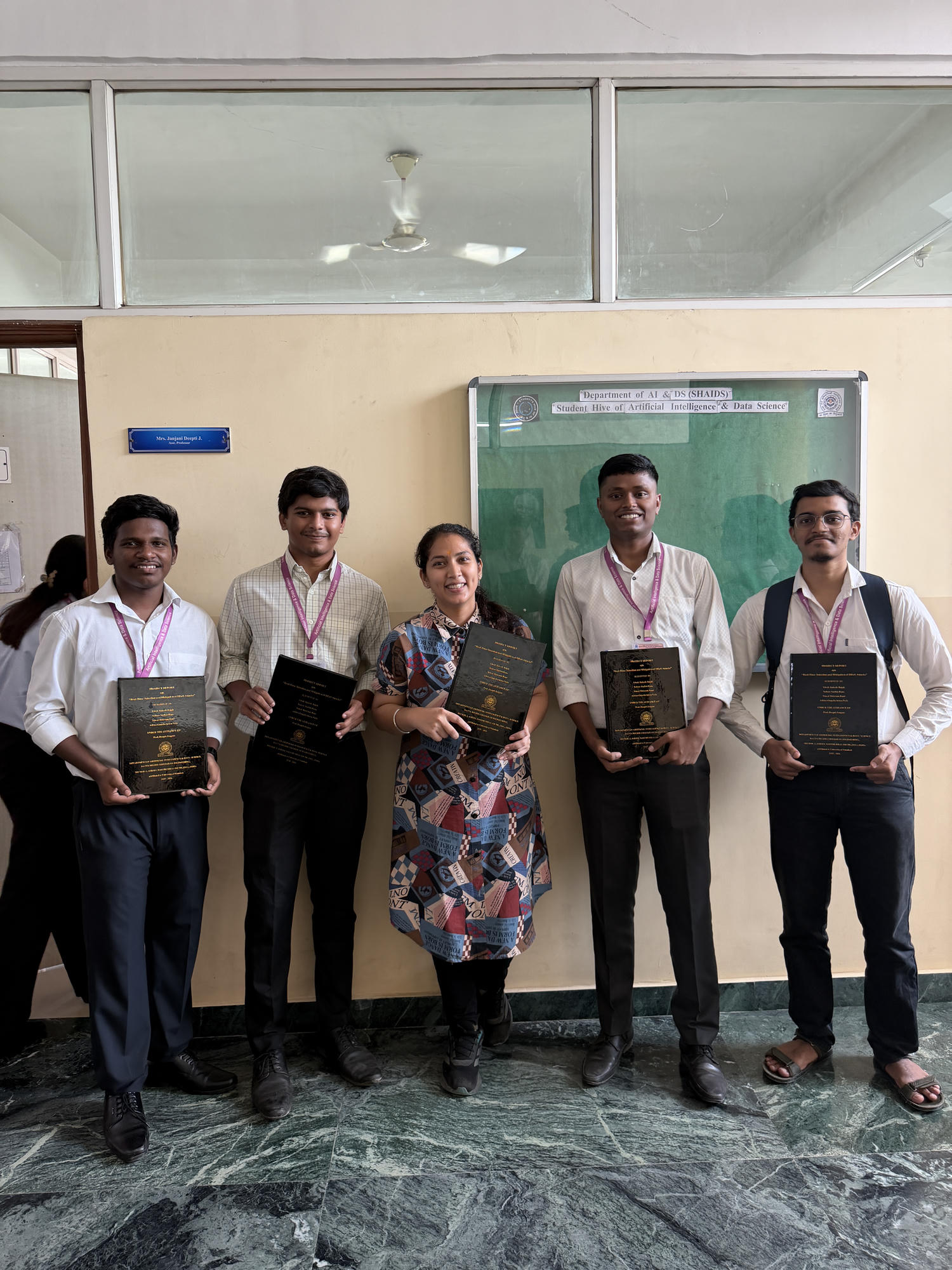 Soham and his final-year DDoS project team holding their project books